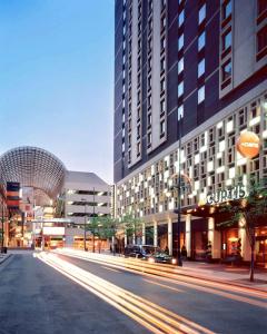 uma rua da cidade com edifícios e uma rua com carros em the Curtis Denver - A DoubleTree by Hilton Hotel em Denver