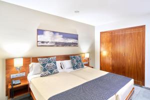 a bedroom with a bed and a wooden cabinet at Hotel Torre Del Conde in San Sebastián de la Gomera
