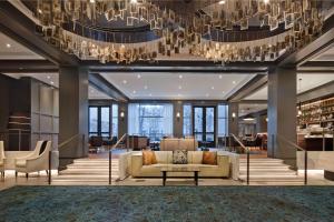 a living room with a couch and a chandelier at The Logan Philadelphia, Curio Collection by Hilton in Philadelphia