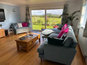 uma sala de estar com um sofá e uma mesa em Westerley Country B & B with exclusive Guest lounge em Buckfastleigh