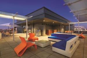 eine Terrasse mit einem blauen Sofa und orangefarbenen Stühlen in der Unterkunft Homewood Suites by Hilton Washington DC Capitol-Navy Yard in Washington