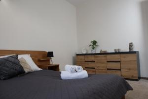 1 dormitorio con 1 cama, vestidor y toallas en Apartament w kamienicy, en Ostróda