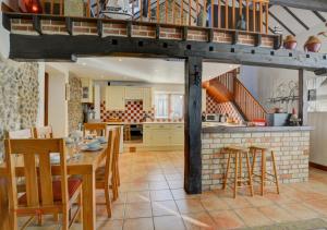 a kitchen and dining room with a table and a fireplace at Swallow Barn in Bodham