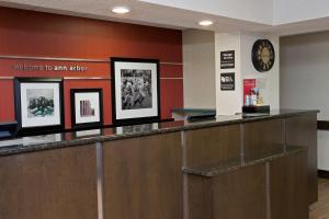 a hotel lobby with a reception counter and a clock at Hampton Inn Ann Arbor - North in Ann Arbor