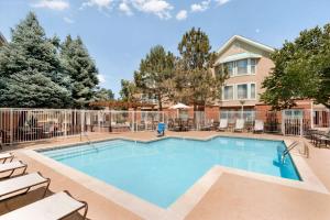 a swimming pool with chairs and a building at Homewood Suites by Hilton Boulder in Boulder