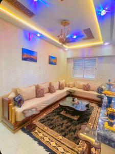 traditional moderne apartment in mohammedia في Ben Yakhlef: غرفة معيشة مع أريكة وطاولة
