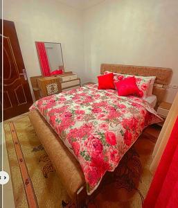 a bedroom with a large bed with red pillows at traditional moderne apartment in mohammedia in Ben Yakhlef