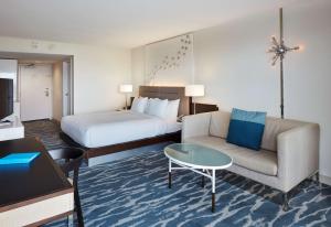 a hotel room with a bed and a couch and a table at Waterstone Resort & Marina Boca Raton, Curio Collection by Hilton in Boca Raton