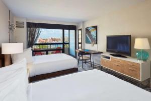 a hotel room with two beds and a flat screen tv at Waterstone Resort & Marina Boca Raton, Curio Collection by Hilton in Boca Raton