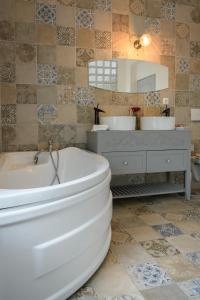 La salle de bains est pourvue d'une baignoire, de 2 lavabos et d'un miroir. dans l'établissement Hotel Vegas Negreni, à Negreni