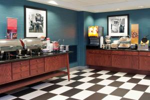 um restaurante com paredes azuis e um piso xadrez em Hampton Inn & Suites Bloomington Normal em Normal