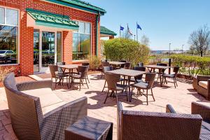 un patio con mesas y sillas frente a un edificio en Hilton Garden Inn Hartford North-Bradley International Airport, en Windsor