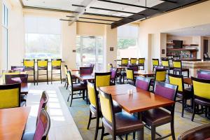 uma sala de jantar com mesas e cadeiras de madeira em Hilton Garden Inn Hartford North-Bradley International Airport em Windsor