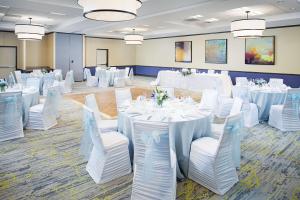 un salón de banquetes con mesas blancas y sillas blancas en Hilton Garden Inn Hartford North-Bradley International Airport, en Windsor