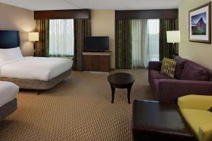 um quarto de hotel com uma cama e um sofá em Hilton Garden Inn Hartford North-Bradley International Airport em Windsor