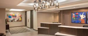 绍姆堡DoubleTree by Hilton Chicago Schaumburg的一间设有吊灯和壁画的等候室