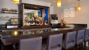 un bar avec des chaises bleues dans un restaurant dans l'établissement DoubleTree by Hilton Hotel Chicago - Schaumburg, à Schaumburg