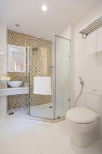 uma casa de banho com uma cabina de duche em vidro e um WC. em Hotel L'Odéon Phu My Hung em Ho Chi Minh