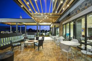 un restaurante con mesas, sillas y ventanas en Home2 Suites By Hilton Decatur Ingalls Harbor, en Decatur
