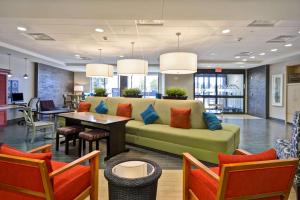a living room with a couch and a table and chairs at Home2 Suites By Hilton Decatur Ingalls Harbor in Decatur