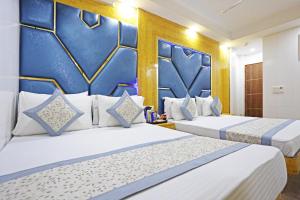 two beds in a hotel room with blue walls at Hotel Preet Palace -5 Mints Walk From Nizamuddin Railway Station in New Delhi