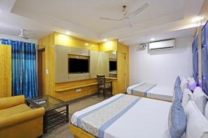 Habitación de hotel con 2 camas y sofá en Hotel Preet Palace -5 Mints Walk From Nizamuddin Railway Station, en Nueva Delhi