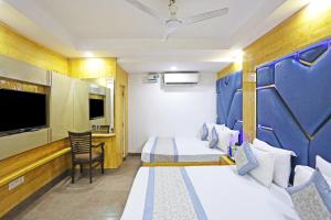 a hotel room with two beds and a flat screen tv at Hotel Preet Palace -5 Mints Walk From Nizamuddin Railway Station in New Delhi