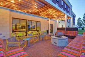 un patio con sedie, tavoli e un camino di Home2 Suites By Hilton Madison Huntsville Airport a Madison