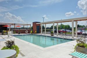 une piscine avec des tables et des chaises dans l'établissement Home2 Suites By Hilton Madison Huntsville Airport, à Madison