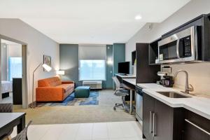 Habitación de hotel con cocina y sala de estar. en Home2 Suites By Hilton Madison Huntsville Airport, en Madison