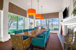 een eetkamer met een houten tafel en blauwe stoelen bij Hilton Garden Inn Wichita in Wichita