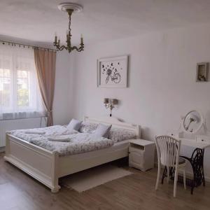 1 dormitorio con cama, mesa y escritorio en Edina Vintage Vendégház en Mosonmagyaróvár