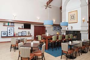 une salle à manger avec des tables, des chaises et une cheminée dans l'établissement Hampton Inn & Suites Kokomo, à Kokomo