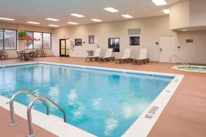 una piscina en un gimnasio con sillas y mesas en Hampton Inn Muskegon, en Muskegon Heights
