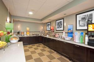a large kitchen with a counter with food on it at Hampton Inn Muskegon in Muskegon Heights