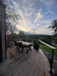 a wooden deck with a table and chairs on it at Chez Laurette in Frémifontaine