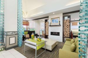 a living room with a couch and a fireplace at Hilton Garden Inn Westbury in Westbury