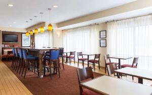 a restaurant with tables and chairs and a bar at Hampton Inn Minneapolis-Burnsville in Burnsville
