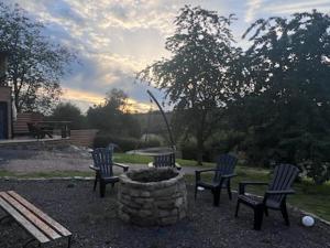 three chairs and a fire pit in a yard at Chez Laurette in Frémifontaine