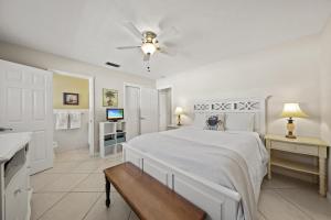 a white bedroom with a bed and a ceiling fan at Sandy Seahorse Cottage in Siesta Key