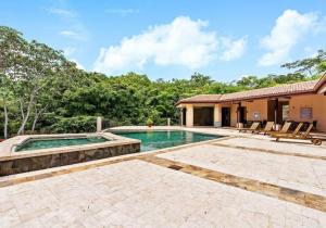 a house with a swimming pool in a yard at Jobo 9 Reserva Conchal in Playa Conchal