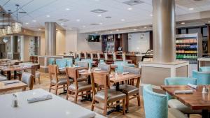 a dining room with tables and chairs in a restaurant at DoubleTree by Hilton Hotel West Palm Beach Airport in West Palm Beach