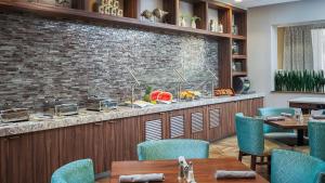 um restaurante com mesas e cadeiras e uma parede de tijolos em DoubleTree by Hilton Hotel West Palm Beach Airport em West Palm Beach