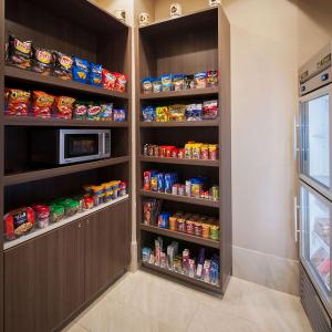 a kitchen with a pantry with lots of food at DoubleTree by Hilton Hotel West Palm Beach Airport in West Palm Beach