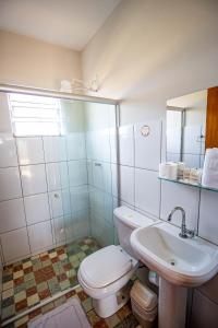 a bathroom with a toilet and a sink at Rancho da Cachaça Pousada in Holambra