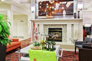 a lobby with a table with bottles and glasses on it at Hilton Garden Inn Springfield, IL in Springfield