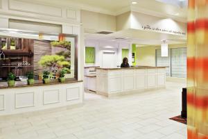 a woman sitting at a counter in a lobby at Hilton Garden Inn Springfield, IL in Springfield