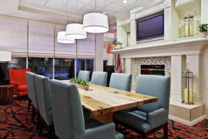 a dining room with a wooden table and chairs at Hilton Garden Inn Springfield, IL in Springfield