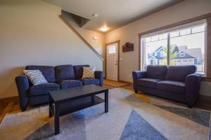 a living room with two blue couches and a table at CDA Hideaway 4 bed 3 Bath Modern Mid Term Rental in Hayden