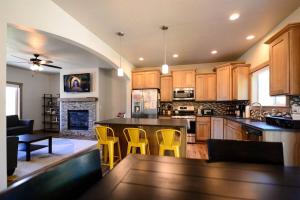 a kitchen with yellow chairs and a kitchen island at CDA Hideaway 4 bed 3 Bath Modern Mid Term Rental in Hayden